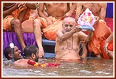 Swamishri gently releases Shri Ganeshji in to the waters of the river Utavali