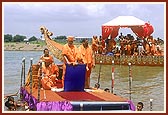 Swamishri is being towed to the river bank on the satellite stage