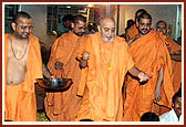 Swamishri blesses the volunteers seated for preparing the boxes of prasad