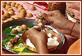 Swamishri ceremoniously bathes Shri Harikrishna Maharaj in panchamrut during the rituals