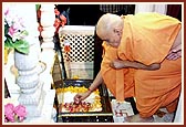 Swamishri reverentially touches the holy charnarvind of Shriji Maharaj