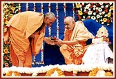 Pujya Mahant Swami offers a bouquet to Swamishri