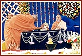 Pujya Kothari Swami offers pujan to Shri Harikrishna Maharaj and thereafter, on behalf of the entire congregation, conveys birthday greetings by tying a nada chhadi on Swamishri's wrist