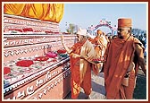 Out of respect Swamishri performs pradakshina and showers flowers on the mantra books