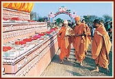 Out of respect Swamishri performs pradakshina and showers flowers on the mantra books