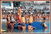 Swamishri bathes Harikrishna Maharaj with the holy water of the river Ghela