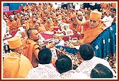 Swamishri sprinkles sanctified water on the yagna participants