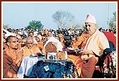 Swamishri waves the arti to Harikrishna Maharaj at mantra book podium
