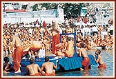 Swamishri bows to all after bathing in the sacred river 