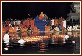 Swamishri on a raised seat on the banks of river Ghela, enabling all to have his darshan during the divo and arti ceremonies