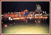 Swamishri on a raised seat on the banks of river Ghela, enabling all to have his darshan during the divo and arti ceremonies