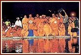 Swamishri and Mahant Swami placed lighted divas into the waters of the river Ghela
