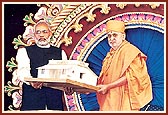As part of the handing over ceremony of BAPS earthquake rehabilitation work in 9 villages and 43 schools, Swamishri presents a model home to the Chief Minister of Gujarat 