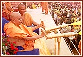 Swamishri sprays the holy colored water on the ecstatic devotees