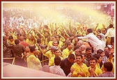 Swamishri sprays the holy colored water on the ecstatic devotees