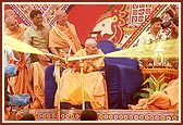 Swamishri profusely blesses the devotees by spraying colored water as they pass by