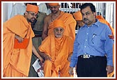 Swamishri enters the neurosurgical ward, lead by Shri S. K. Nanda, Health Secretary