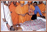 Swamishri is apprised of Shrujan Singh's condition, the NSG commando injured during Operation Thundernight, by the doctors and blesses him and prays for his recovery. Swamishri gently blesses him with the touch of his hand and showers sacred rose petals