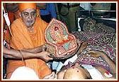 Swamishri holds Harikrishna Maharaj before each of the injured, blesses them by gently placing his hand on them and encourages them with words for their quick recovery