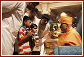 After the assembly Swamishri consoles and blesses relatives of the deceased victims inside the main monument