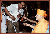 After the assembly Swamishri consoles and blesses relatives of the deceased victims inside the main monument