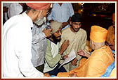 After the assembly Swamishri consoles and blesses relatives of the deceased victims inside the main monument