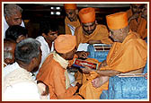 After the assembly Swamishri consoles and blesses relatives of the deceased victims inside the main monument