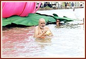 Swamishri bathing in the river Utavali. 