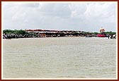 The river Utavali with devotees and sadhus seated on the banks.