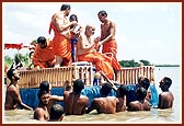 Swamishri bathes with fresh water after emerging from his holy dip.