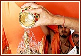 Swamishri bathes Shri Harikrishna Maharaj with water from the holy rivers.