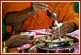Swamishri ceremoniously bathes Shri Harikrishna Maharaj with panchamrut during the rituals