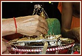 Swamishri ceremoniously bathes Shri Harikrishna Maharaj with panchamrut during the rituals 