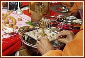   Swamishri ceremoniously bathes Shri Harikrishna Maharaj with panchamrut during the rituals