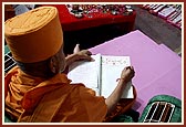 Swamishri writes his blessings in the mandir account book