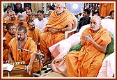 Swamishri devotionally sings the thals before Thakorji