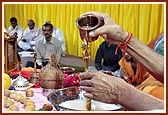 Swamishri ceremoniously bathes the deities with water 