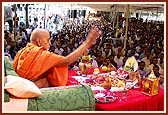 Swamishri blesses the devotees by showering rice grains (ashirvad) 