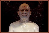 Abhishek of panchamrut and saffron water on the murtis of Shastriji Maharaj and Pramukh Swami Maharaj