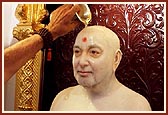 Abhishek of panchamrut and saffron water on the murtis of Shastriji Maharaj and Pramukh Swami Maharaj