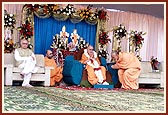 Swamishri is honored with a garland by Pujya Mahant Swami