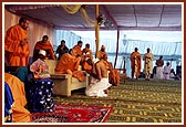 Pujya Doctor Swami gives the gatariyu and Pujya Mahant Swami places the pagh on each parshad