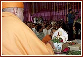 Swamishri offers tulsi leaves to Thakorji during the chanting of Janmangal Namavali