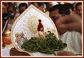 Swamishri offers tulsi leaves to Thakorji during the chanting of Janmangal Namavali
