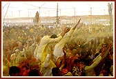 Devotees euphorically raise their hands holding plastic bags and bottles to collect and be blessed with the holy, colored water