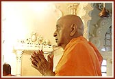 Swamishri with folded hands before the murtis of Dharmakul in the last shrine