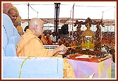 Swamishri sprinkles colored water on Shri Harikrishna Maharaj