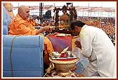 Swamishri sprays the sanctified colored water on the distinguished guests 