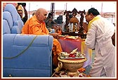 Swamishri sprays the sanctified colored water on the distinguished guests 