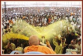 Devotees ecstatically raise their hands and dance to be blessed with the shower of holy, colored water
